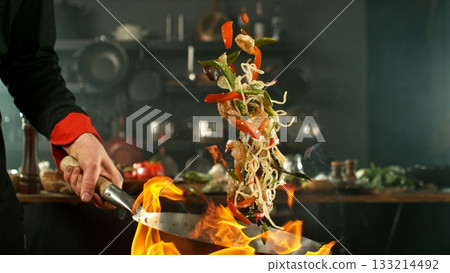 Freeze Motion of Flying Asian Meal with Vegetable and Prawns into Wok Pan 133214492