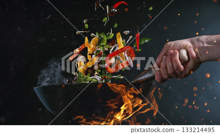 Freeze Motion of Flying Asian Meal with Vegetable and Prawns into Wok Pan 133214495