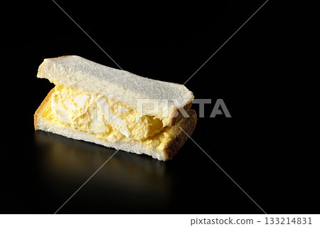 Egg sandwich photographed alone against a black background Egg sandwich photographed alone against a black background 133214831