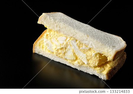 Egg sandwich photographed alone against a black background Egg sandwich photographed alone against a black background 133214833