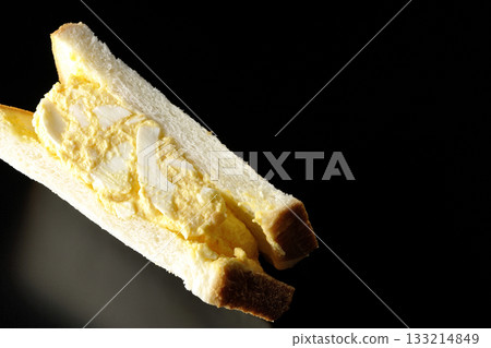 Egg sandwich photographed alone against a black background Egg sandwich photographed alone against a black background 133214849