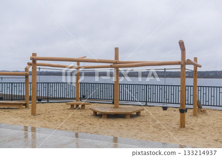 Wooden Playground on the embankment on a cloudy day in winter. 133214937