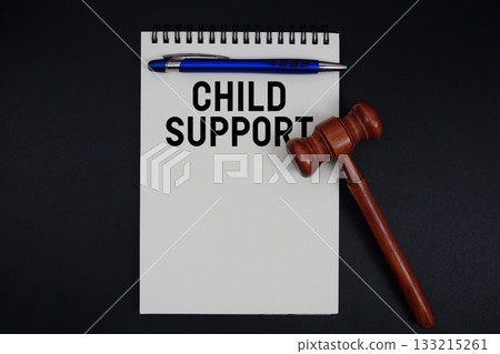 Child Support text written on notepad with gavel on black background 133215261