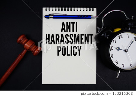 Anti-Harassment Policy text written on notepad with gavel and alarm clock on black background 133215308
