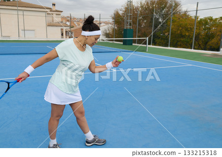 Female Tennis Player On Blue Court Practicing Backhand Grip With Ball And Racket 133215318
