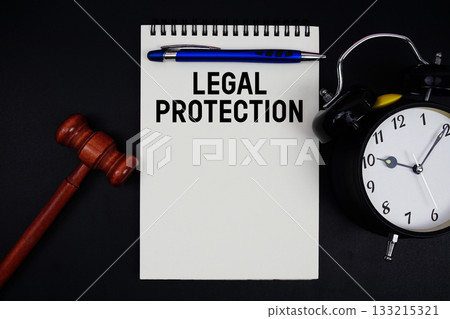 Legal Protection text written on notepad with gavel and alarm clock on black background 133215321