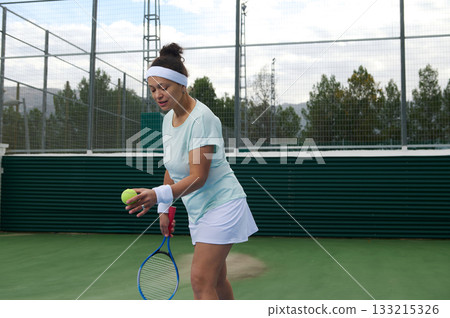Female Tennis Player In Light Blue Outfit On Outdoor Court With Racket And Ball 133215326