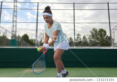 Female Tennis Player In Light Blue Shirt And White Skirt Preparing To Return Ball On Court Female Tennis Player In Light Blue Shirt And White Skirt Preparing To Return Ball On Court 133215335
