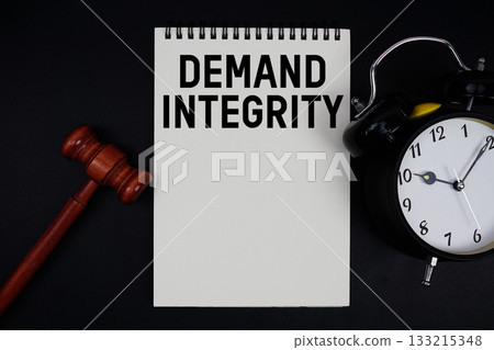 Demand Integrity text written on notepad with gavel and alarm clock on black background Demand Integrity text written on notepad with gavel and alarm clock on black background 133215348