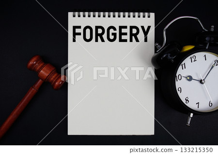 Forgery text written on notepad with gavel and alarm clock on black background 133215350