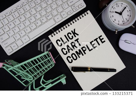 Click. Cart. Complete text written on notepad with keyboard and trolley shopping cart on black background 133215371