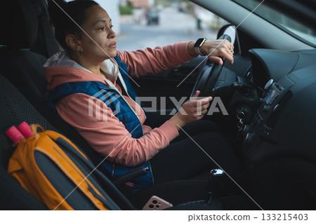 Woman Driving Car in Casual Outfit, Focused Moment Behind the Wheel for Urban Travel Woman Driving Car in Casual Outfit, Focused Moment Behind the Wheel for Urban Travel 133215403