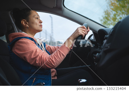 Focused Driver In A Cozy Car Cabin, Woman Steering With Calm Confidence On A Day Drive 133215404