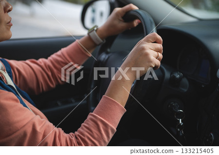 Woman Driving Car With Hands On Steering Wheel Inside Vehicle For Safe, Focused Travel Woman Driving Car With Hands On Steering Wheel Inside Vehicle For Safe, Focused Travel 133215405