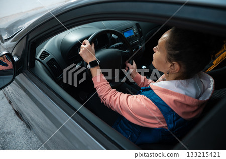 Woman Driving Car With Pink Hoodie And Blue Vest Inside Modern Vehicle For Focused Commute 133215421