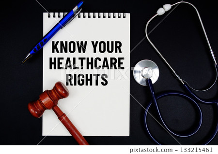 Notepad with "Know Your Healthcare Rights" a pen, gavel, and stethoscope on a black background 133215461
