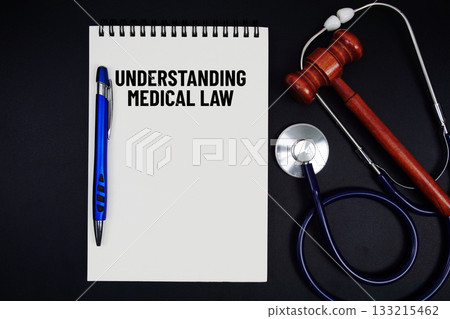 Notepad with "Understanding Medical Law" a pen, gavel, and stethoscope on a black background Notepad with "Understanding Medical Law" a pen, gavel, and stethoscope on a black background 133215462