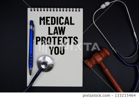 Notepad with "Medical Law Protects You" a pen, gavel, and stethoscope on a black background 133215464