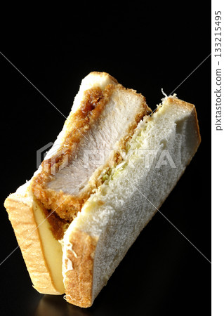 Thick-cut pork cutlet sandwich photographed alone against a black background Thick-cut pork cutlet sandwich photographed alone against a black background 133215495