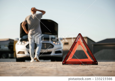 Unfortunate, transport is broken, red sign. Man is with his car outdoors 133215566