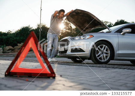 Unfortunate, transport is broken, red sign. Man is with his car outdoors Unfortunate, transport is broken, red sign. Man is with his car outdoors 133215577