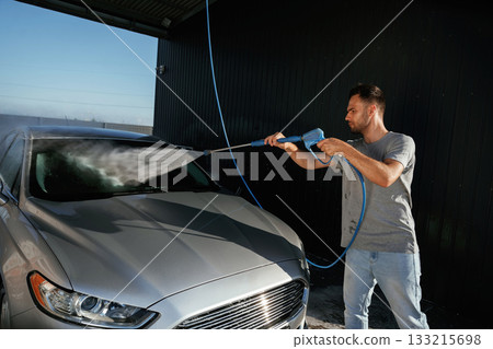 Silver colored surface, washing the automobile. Man is with his car outdoors 133215698