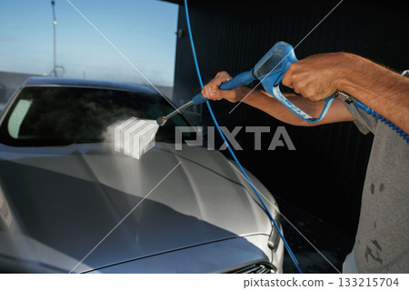 Side view, car wash, high pressure. Man is with his automobile outdoors Side view, car wash, high pressure. Man is with his automobile outdoors 133215704