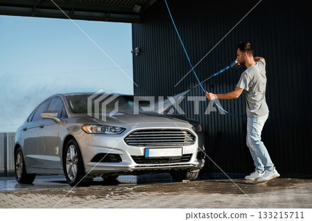 Self-service car wash. Man is with his automobile outdoors Self-service car wash. Man is with his automobile outdoors 133215711