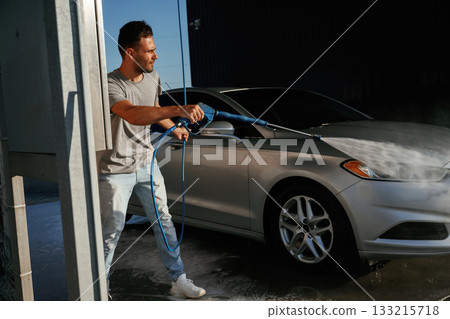 Service of car wash. Man is with his automobile outdoors 133215718