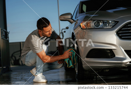 Business of car washing, polishing. Man is with automobile outdoors Business of car washing, polishing. Man is with automobile outdoors 133215744