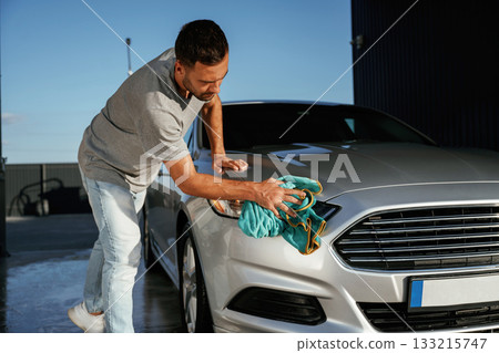 Business of car washing, polishing. Man is with automobile outdoors Business of car washing, polishing. Man is with automobile outdoors 133215747