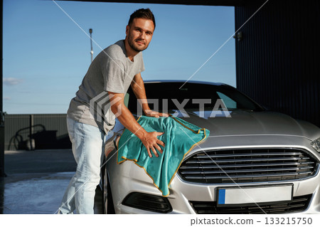 Turquoise cloth, polishing the vehicle. Man is with his car outdoors Turquoise cloth, polishing the vehicle. Man is with his car outdoors 133215750