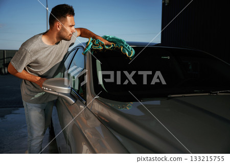 Working, polishing the automobile. Man is with his car outdoors Working, polishing the automobile. Man is with his car outdoors 133215755