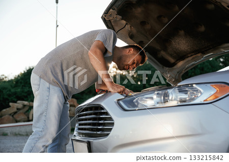 Breakdown, hood is opened, repairing. Man is with his car outdoors Breakdown, hood is opened, repairing. Man is with his car outdoors 133215842