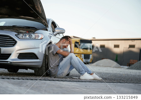 Accident, broken automobile is parked. Man is with his car outdoors 133215849