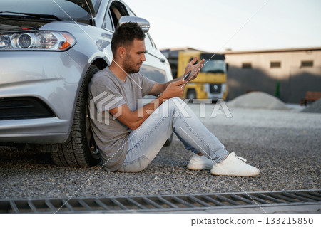Accident, broken automobile is parked. Man is with his car outdoors Accident, broken automobile is parked. Man is with his car outdoors 133215850
