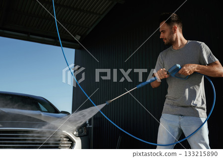Taking care of washing. Man is with his car outdoors Taking care of washing. Man is with his car outdoors 133215890