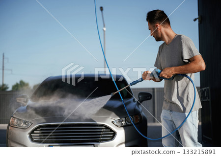 Taking care of washing. Man is with his car outdoors 133215891