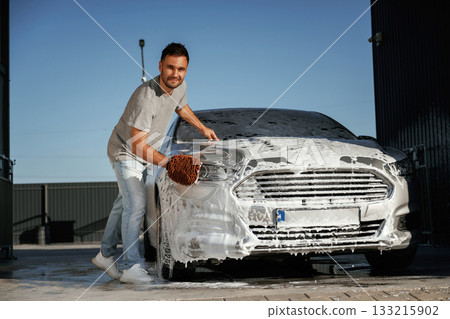 White cleaning chemical, washing the automobile. Man is with his car outdoors 133215902