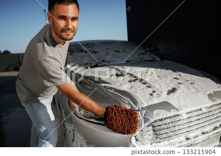 Process of washing the automobile. Man is with his car outdoors 133215904