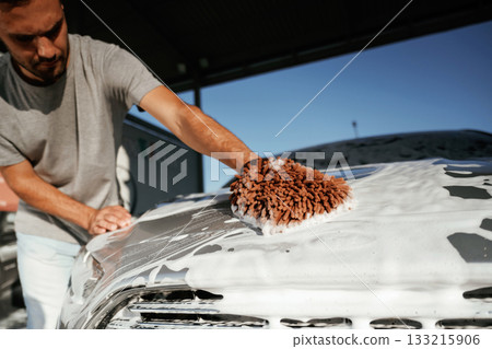 White cleaning chemical, washing the automobile. Man is with his car outdoors White cleaning chemical, washing the automobile. Man is with his car outdoors 133215906