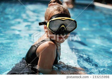 In swimming mask. Happy little girl is having fun in the pool 133215998