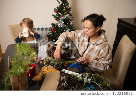 Family Christmas Crafting At Home: Mother And Child Making Pinecone Decorations 133216091