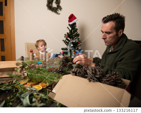 Family Christmas Crafting: Father And Child Create Decorations At Home By The Tree 133216117