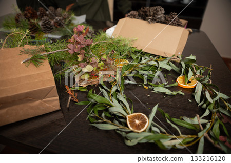 Family Christmas Crafts With Natural Greens And Dried Citrus Decorations On Table Family Christmas Crafts With Natural Greens And Dried Citrus Decorations On Table 133216120