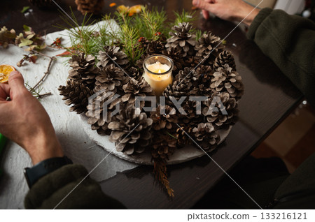 Winter Wreath Craft With Pine Cones And Candle In Cozy Home Setting 133216121