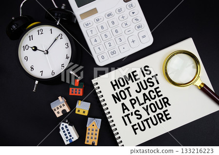 Notepad with the phrase "Home Is Not Just A Place It's Your Future" surrounded by a pen, calculator, magnifying glass, clock, and house model 133216223