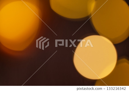 Yellow lights with a bokeh effect on a dark background close up. Yellow lights with a bokeh effect on a dark background close up. 133216342