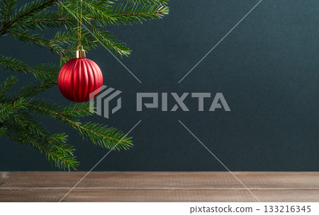 Fir branches with a star-shaped Christmas tree ornament on a dark and wooden background. Fir branches with a star-shaped Christmas tree ornament on a dark and wooden background. 133216345