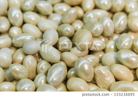 Close-up of brown dragee, chocolate covered nuts, sweet candy background. Close-up of brown dragee, chocolate covered nuts, sweet candy background. 133216895